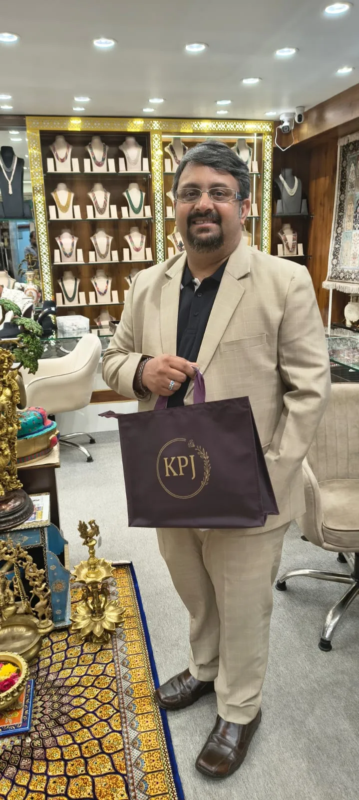 Happy customer at Krishna Pearls boutique holding a KPJ shopping bag